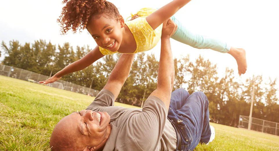 Active grandparent playing with child outdoors to support healthy movement, mobility and everyday wellness