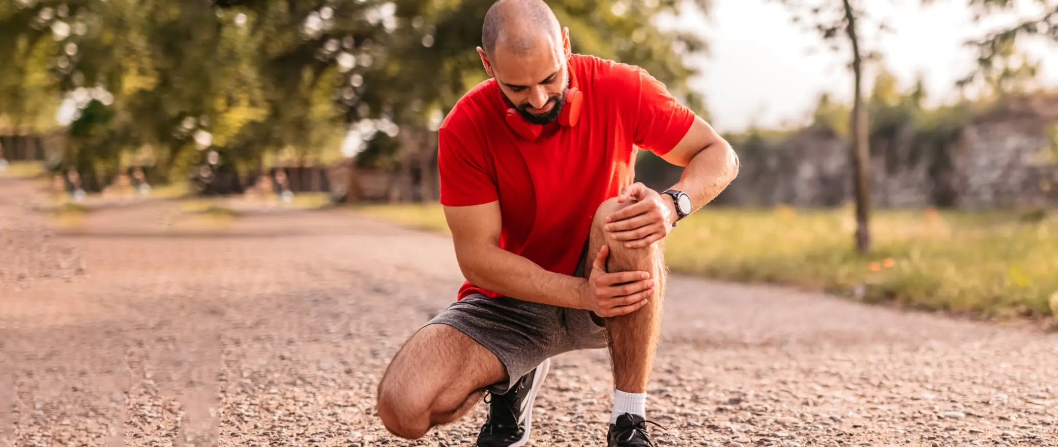 Runner experiencing knee pain during outdoor exercise, highlighting knee support and rehabilitation solutions