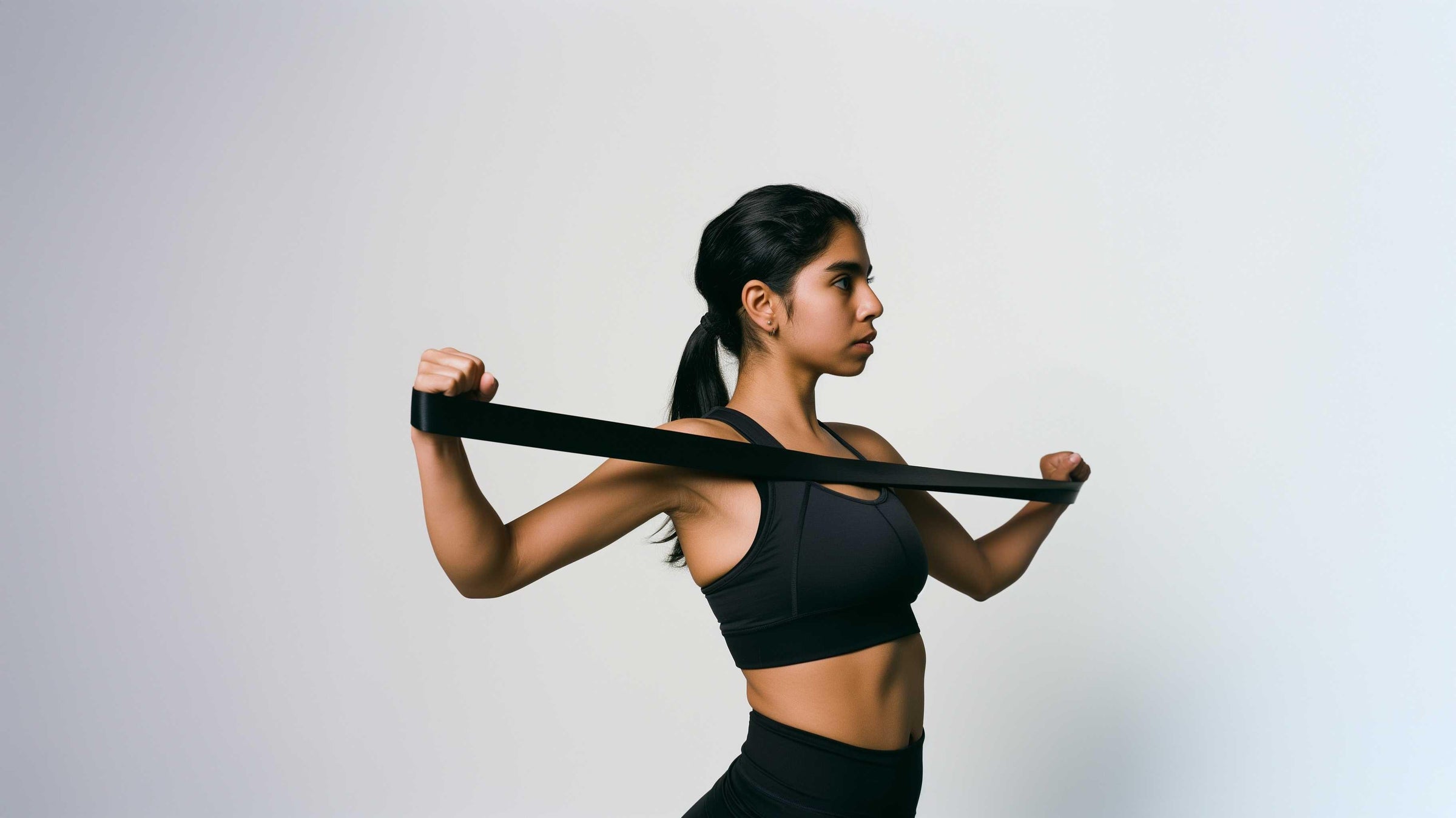 Woman using black resistance band for strength training and rehabilitation exercises